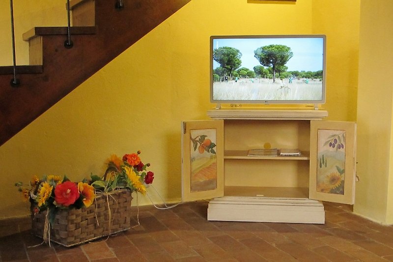 Von Simona Bonelli handbemalte Fernseh-Konsole, deren Innentüren toskanische Landschaftsmotive darstellen.