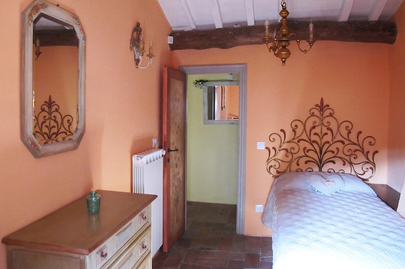 Algunos de los muebles antiguos y pintados a mano en la habitación de Pinocho, que es una habitación individual, crean un ambiente acogedor.