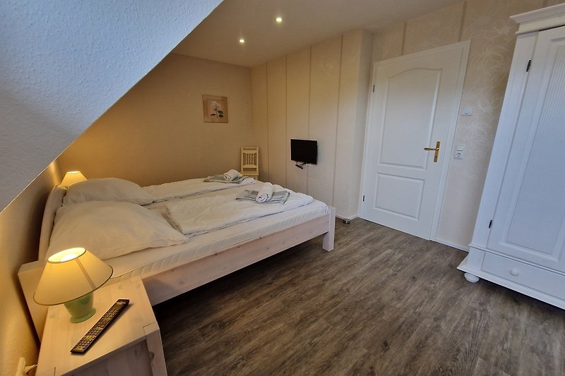 Komfortables Schlafzimmer mit stilvollem Holzmöbel und gemütlichem Bett.