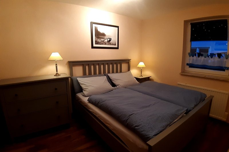 Ein stilvolles Schlafzimmer mit Holzboden und elegantem Lampenschirm.