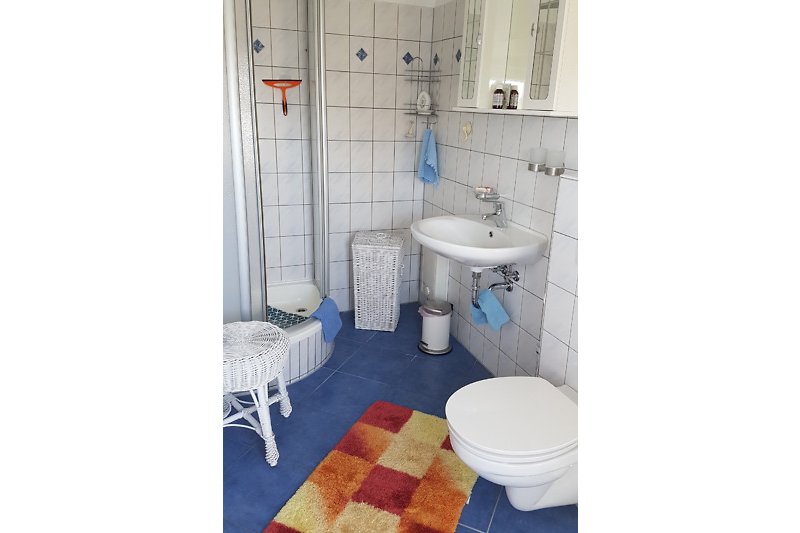 Modernes Badezimmer mit lila Akzenten und Holzmöbeln.