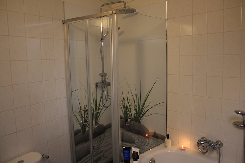 Badezimmer mit Duschkabine, WC, Badewanne, Waschtisch mit Unterbauschrank und Spiegel