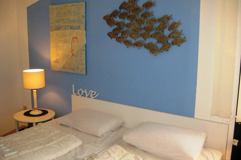 Schlafzimmer mit komfortablem Doppelbett, Kommode, Spiegel, Konsolen und stilvoller Beleuchtung.
