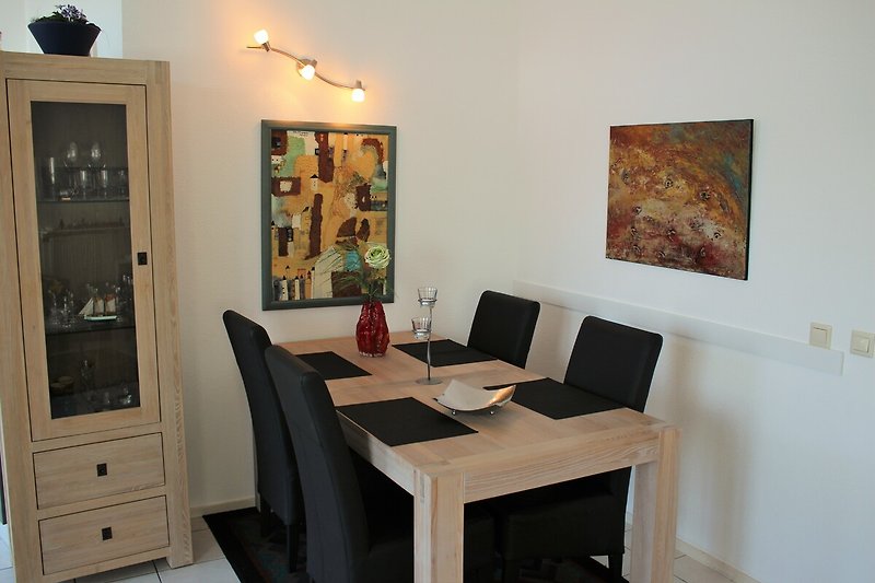 Eßbereich mit Tisch, 4-5 Stühlen, Glasvitrine und Bildern
