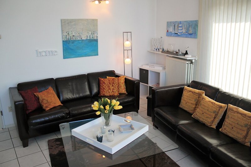 Wohnraum mit gemütlichen Couchmöbeln, Leder und Glastisch