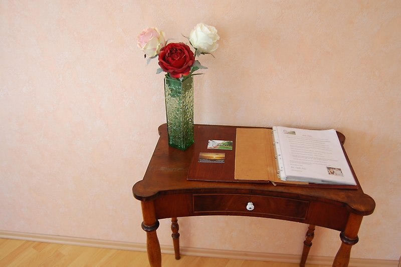 Ein stilvolles Zimmer mit Holzmöbeln und einer Blumenvase.