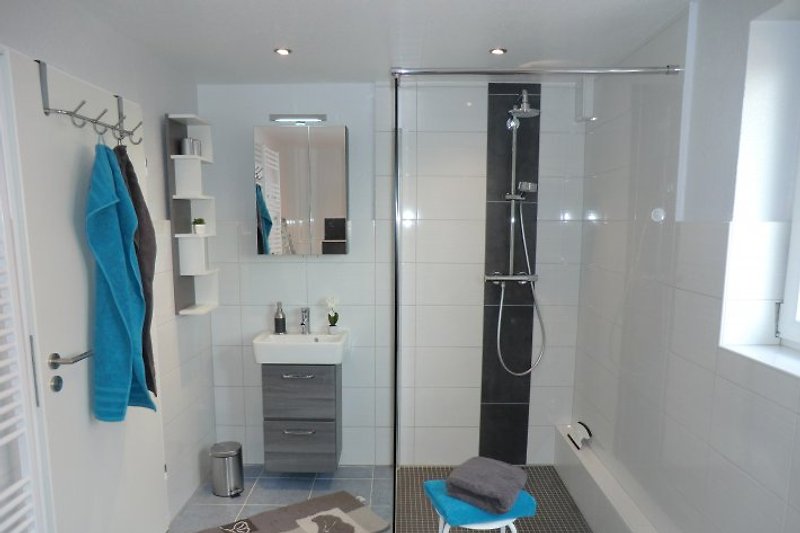 Badezimmer mit ebenerdiger Rainshower-Dusche und direktem Zugang zur Sauna