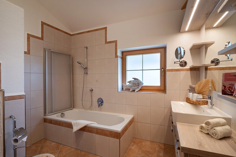 Badezimmer mit Wannenbad und WC. Handtücher inklusive.