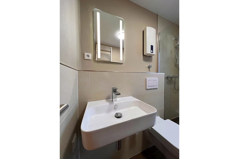 Ein modernes Badezimmer mit Spiegel, Waschbecken und stilvoller Einrichtung.