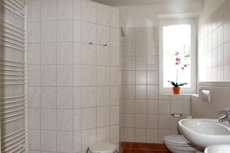 A large bathroom with a walk-in shower and two sinks.