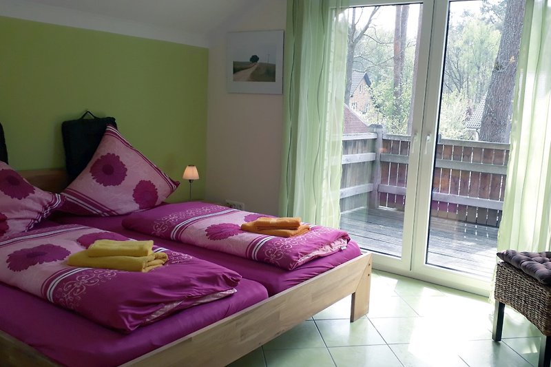 Das Schlafzimmer mit Doppelbett und Ausgang zum Balkon