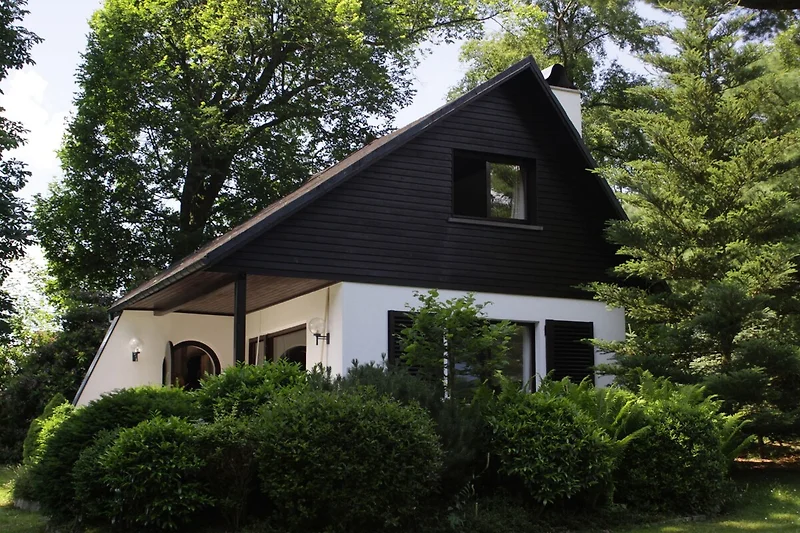 Landhuis met rood dak en groene struiken