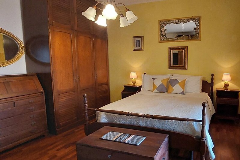 Elegantes Schlafzimmer mit Holzmöbeln und stilvoller Beleuchtung.