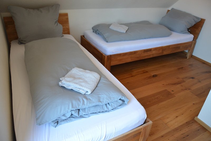 Schlafzimmer mit bequemem Bett und Holzmöbeln.