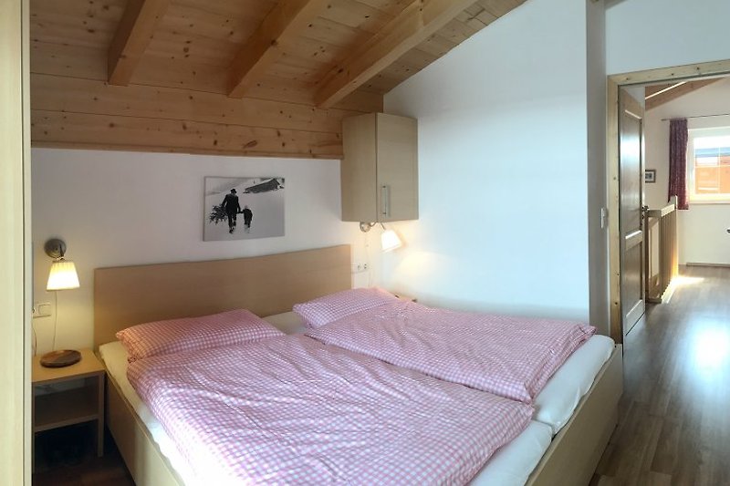 Gemütliches Schlafzimmer mit Holzmöbeln und großem Doppelbett
