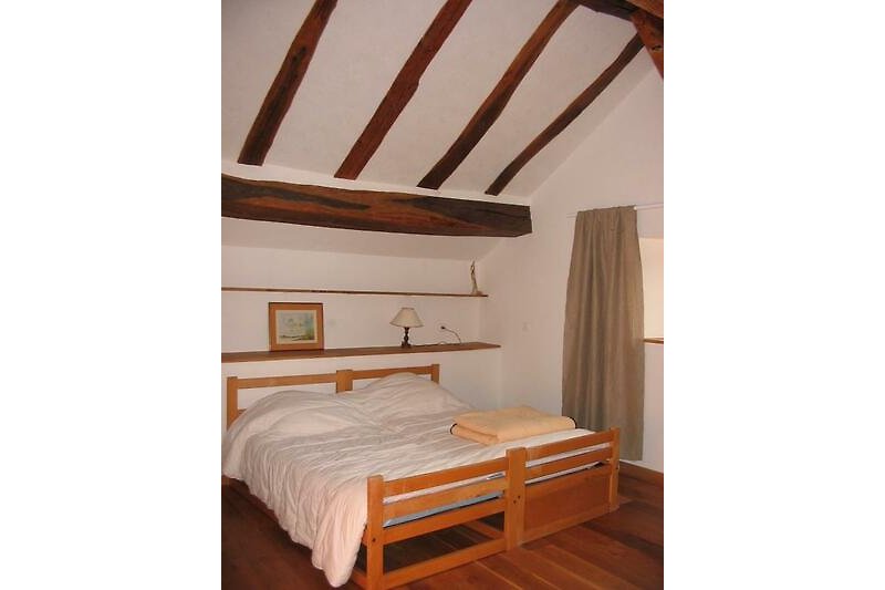 Un intérieur en bois chaleureux avec un lit confortable et des rideaux élégants.