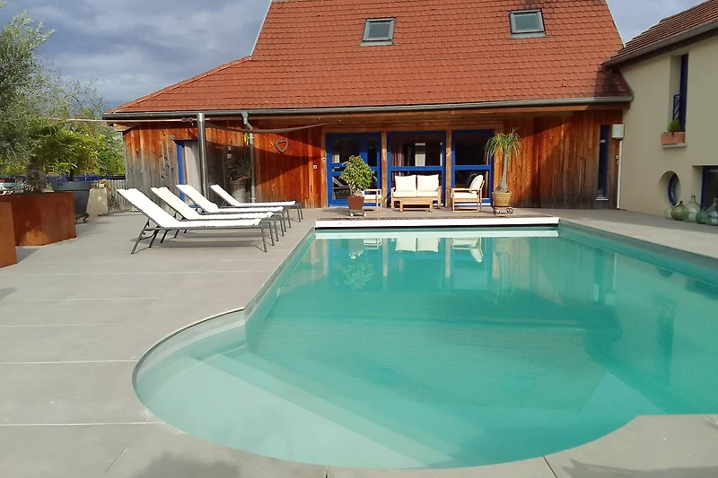 Luxuriöser Poolbereich mit Sonnenliegen und schattigen Sitzgelegenheiten.