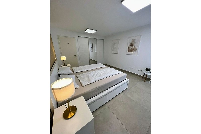 Gemütliches Schlafzimmer mit stilvollem Interieur und Holzboden.