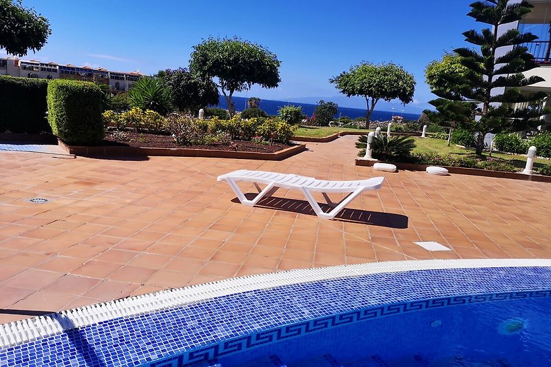 Gemeinschafts-Schwimmbad und Sonnenliege in einem schönen Garten mit Blick aufs Meer(Insel La Gomera im Hintergrund)