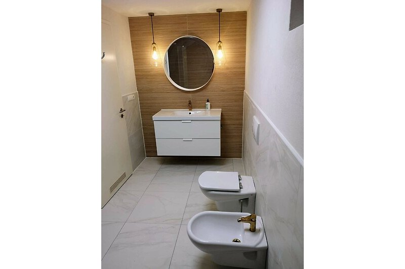 Modernes Bad mit Waschbecken mit Unterschrank, WC und Bidet
