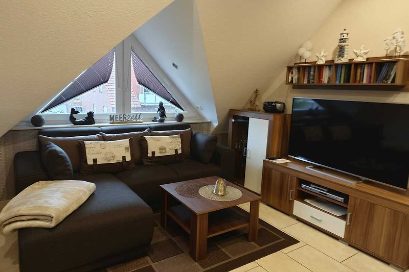 Wohnzimmer mit bequemer Couch, Holzmöbeln und gemütlicher Beleuchtung.