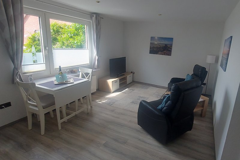 Modernes stillvolles  Wohnzimmer mit Relax Sesseln  und Smart TV Fenster mit  einem Panorama Blick.