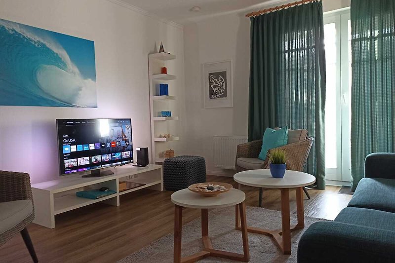 Modernes Wohnzimmer mit Sofa, Couchtisch und großem Flachbildfernseher.