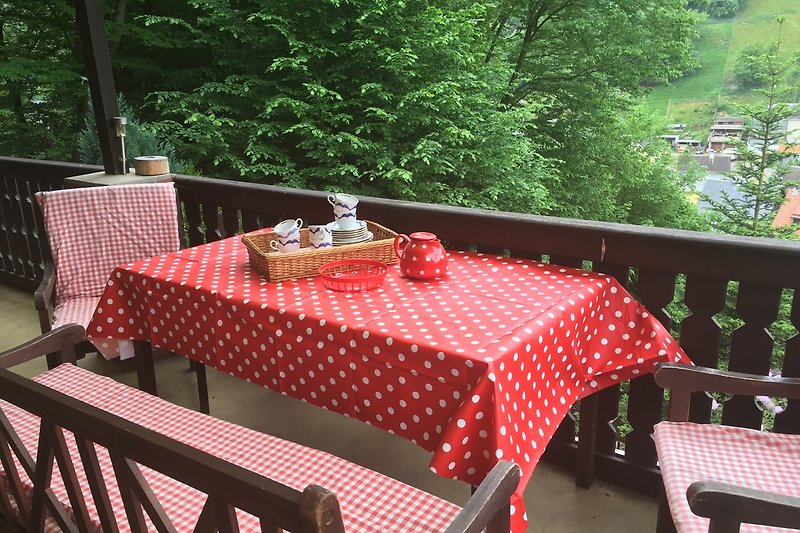 Gedeckter Holztisch im Garten mit Essen und stilvollen Dekorationen.