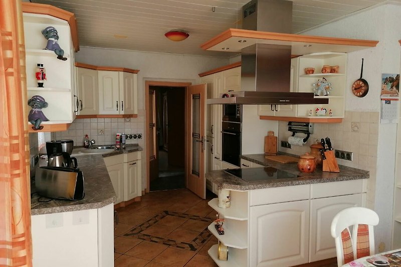 Stilvolle Küche mit hochwertigen Geräten und Holzmöbeln.