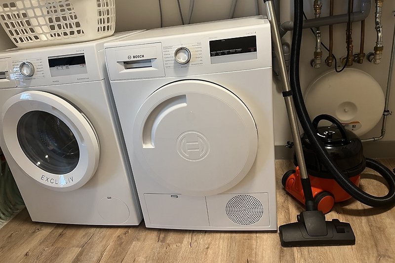 Moderne Waschmaschine und Trockner in stilvollem Waschraum.