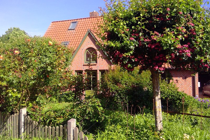 Schönes Haus mit blühendem Garten und malerischer Landschaft.