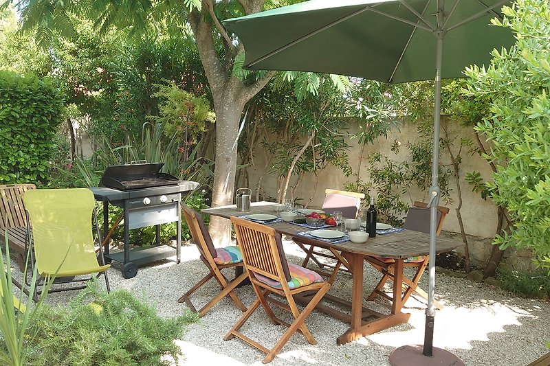 Entspannte Terrasse mit Gartenmöbeln und Sonnenschirm.