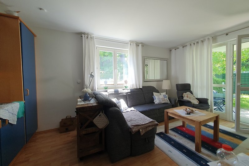 Gemütliches Wohnzimmer mit Holzboden, bequemer Couch und Pflanzen.