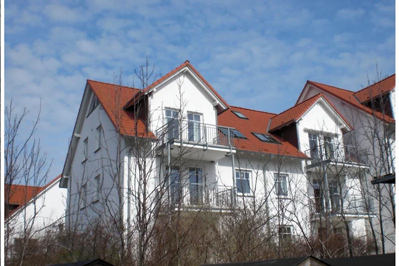 Historisches Haus mit markanter Fassade, Balkon und Sprossenfenstern.