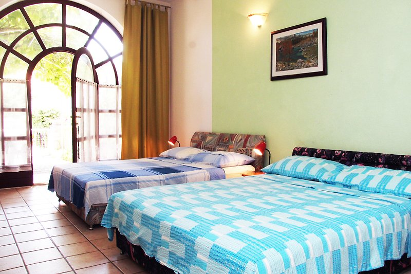 Gespavaća sobamütliches Schlafzimmer mit komfortablem Bett und stilvoller Beleuchtung.