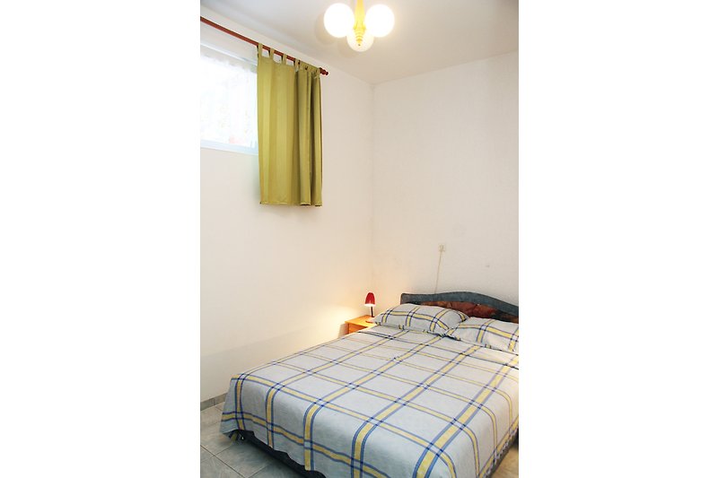 Gemütspavaća soba 2liches Schlafzimmer mit stilvollem Bett und angenehmer Beleuchtung.