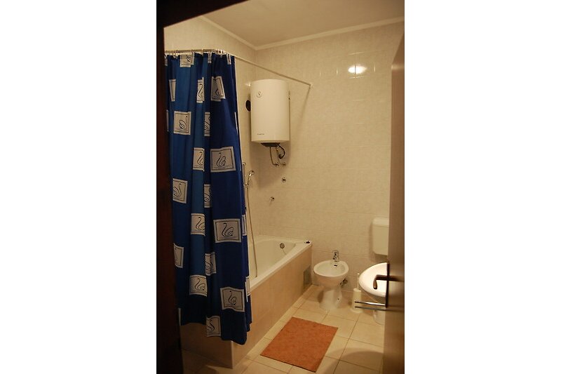 Badezimmer mit lila Duschvorhang, Toilette und Waschbecken.