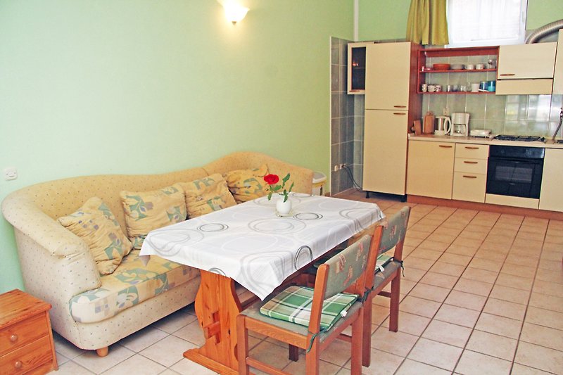 Gekdnevni boravakuhinjamütliche Einrichtung mit Holzmöbeln und Küchengeräten.