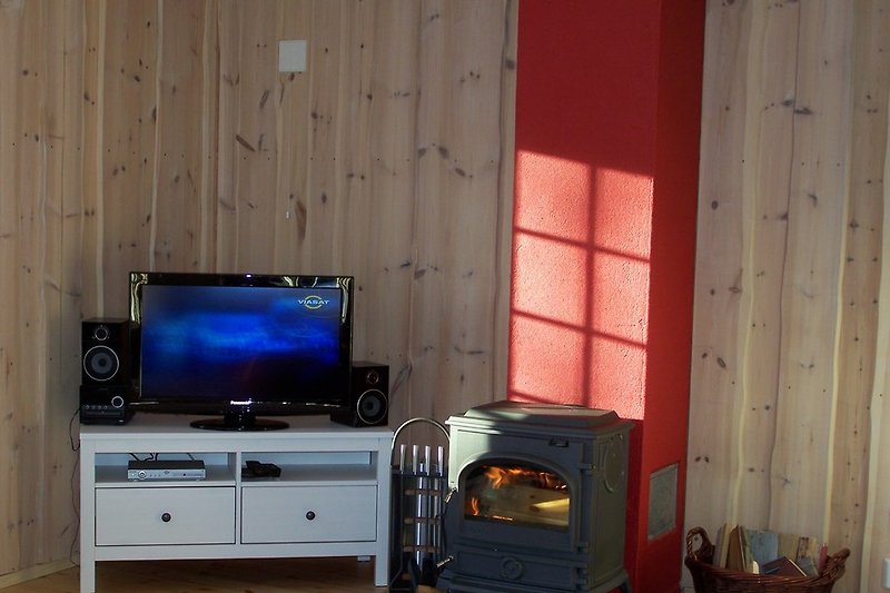 TV, Stereoanlage und Kaminofen im Wohnzimmer