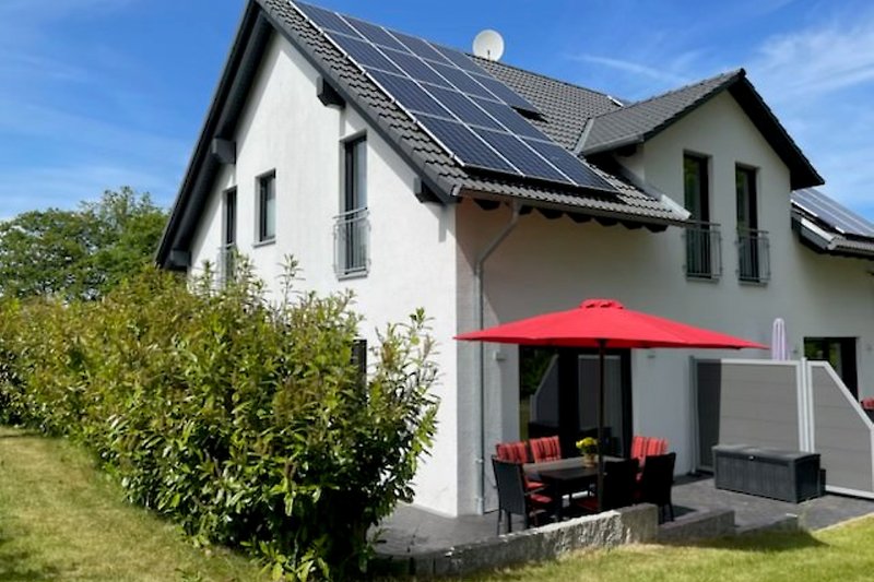 Modernes Ferienhaus "Zeit für Rügen" mit Solarpanelen, Garten und gemütlicher Terrasse.