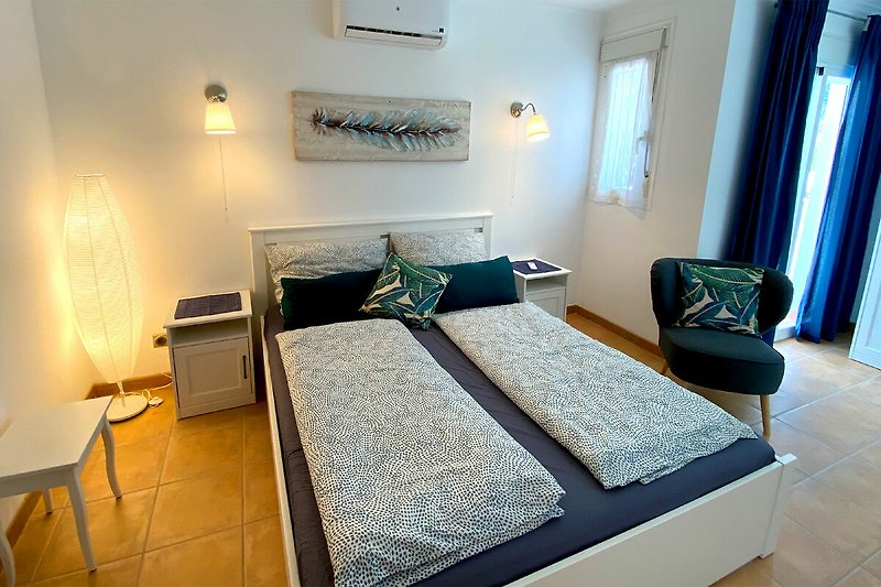 Schlafzimmer im Obergeschoß 160x200 mit gemütlichem Bett, Schrankraum und kleinem Balkon