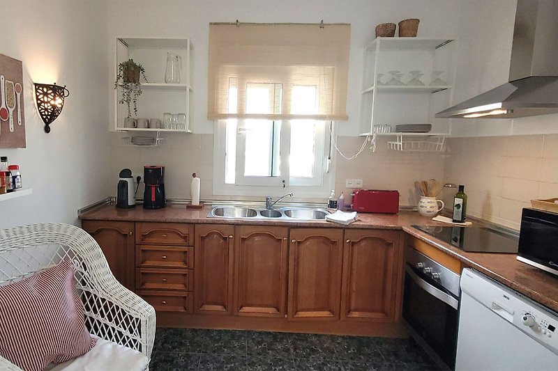 Komplett ausgestattete Küche mit u.a. großem Kühlschrank, Spülmaschine, und Mikrowelle