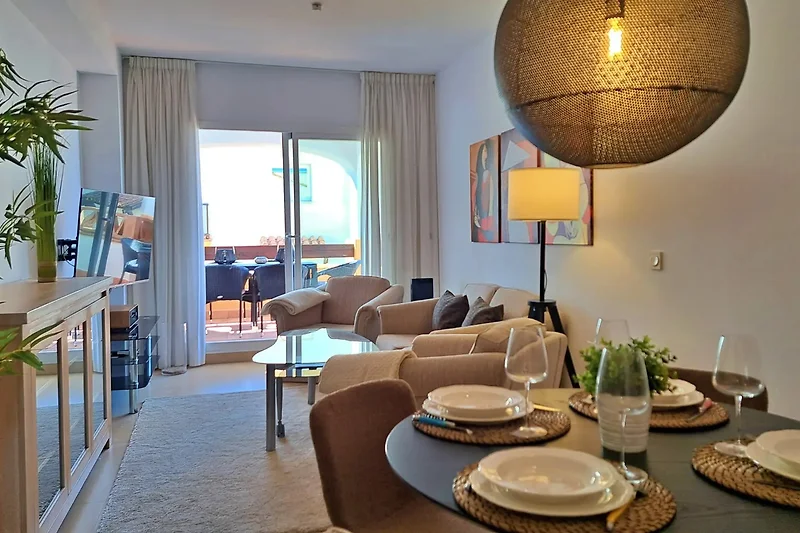 das stilvoll eingerichtete Wohnzimmer mit Sofa und zwei Sesseln, hier steht auch der Esstisch