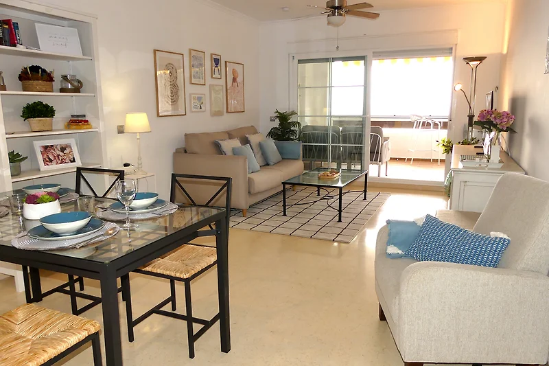 das geschmackvoll eingerichtete Wohnzimmer mit breiter Terrassentür zum überdachten Balkon