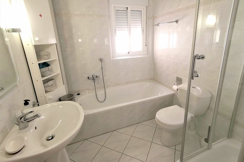 Modernes Badezimmer mit Dusche, Spiegel und Badewanne und WC im Erdgeschoß