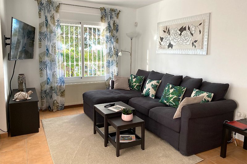 Wohnzimmer mit bequemer Couch und Smart TV