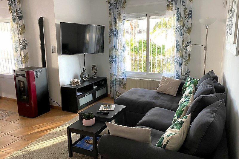 Stilvolles Wohnzimmer mit bequemer Couch und Smart TV