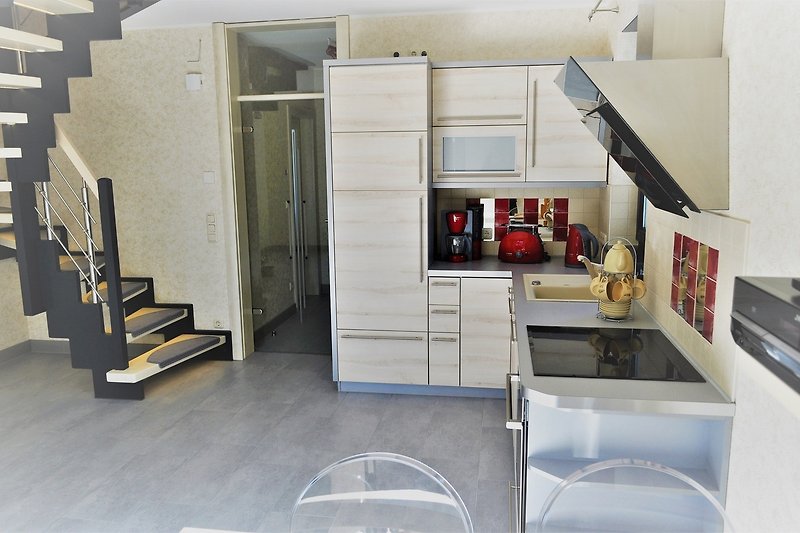 Küche mit Holzregalen, Kabinett und Kühlschrank.