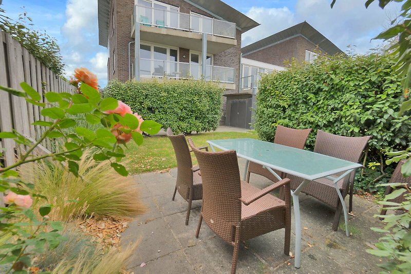 Genießen Sie die Natur auf der Terrasse mit Tisch, Stühlen und Pflanzen.