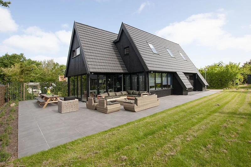 Schönes Haus mit grünem Garten und blauem Himmel.